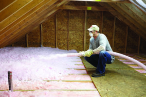 Blown-in fiberglass insulation installation in an attic